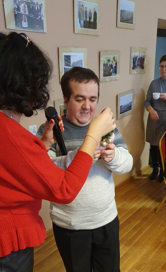 Mężczyzna który zaśpiewał kolęde otrzymuje upominek od pani Prezes