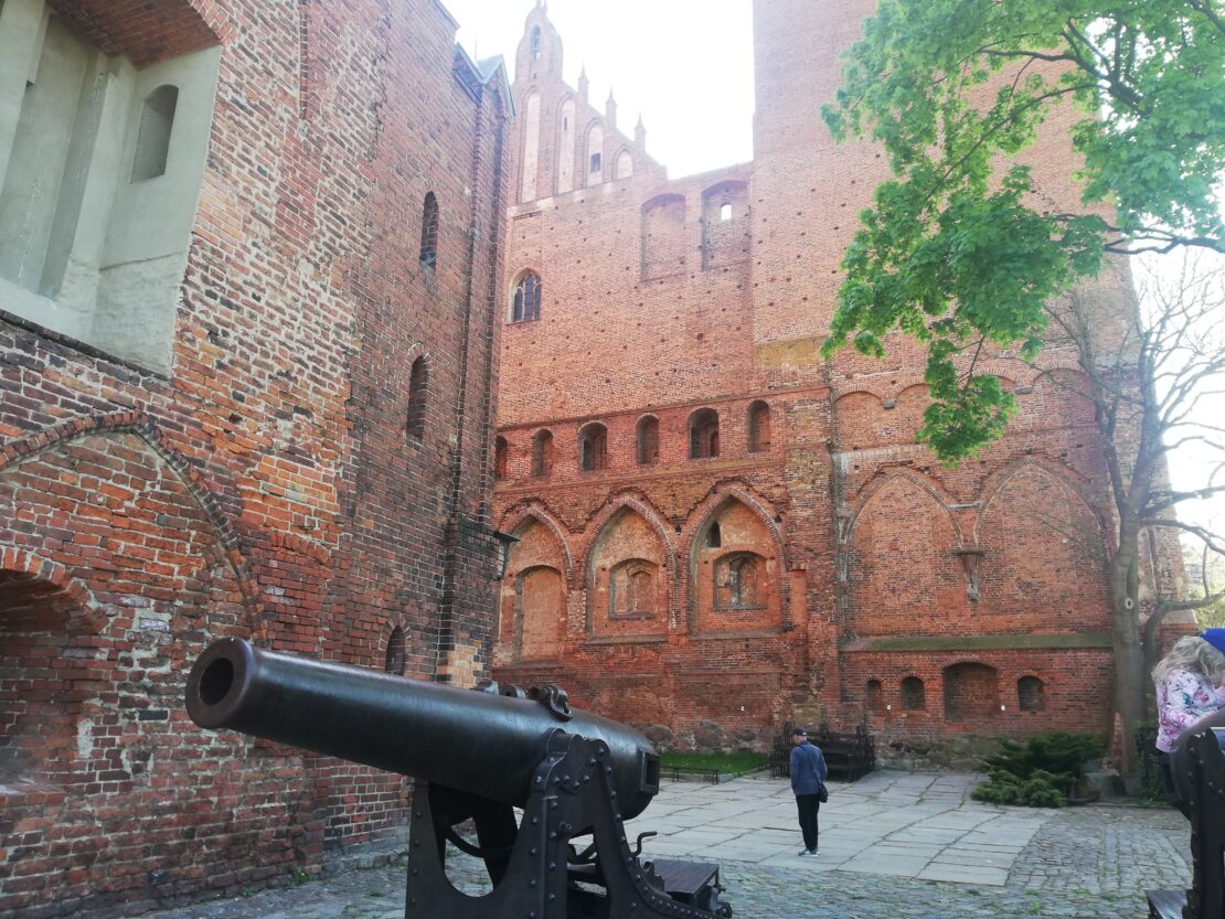 Widok na plac zamkowy, na którym znajduje się armata