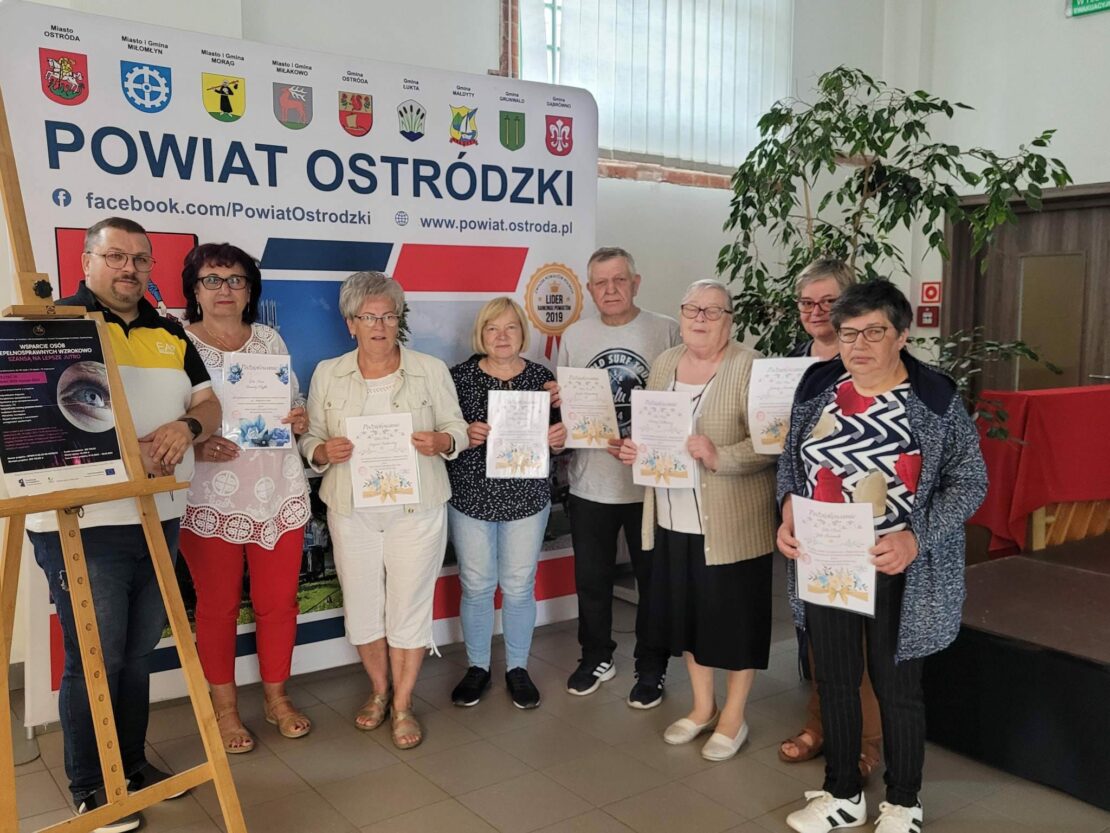 Zdjęcie grupowe uczestników projektu. Wszyscy trzymają dyplomy na zakończenie spotkań. Widać uśmiech na ich twarzach.