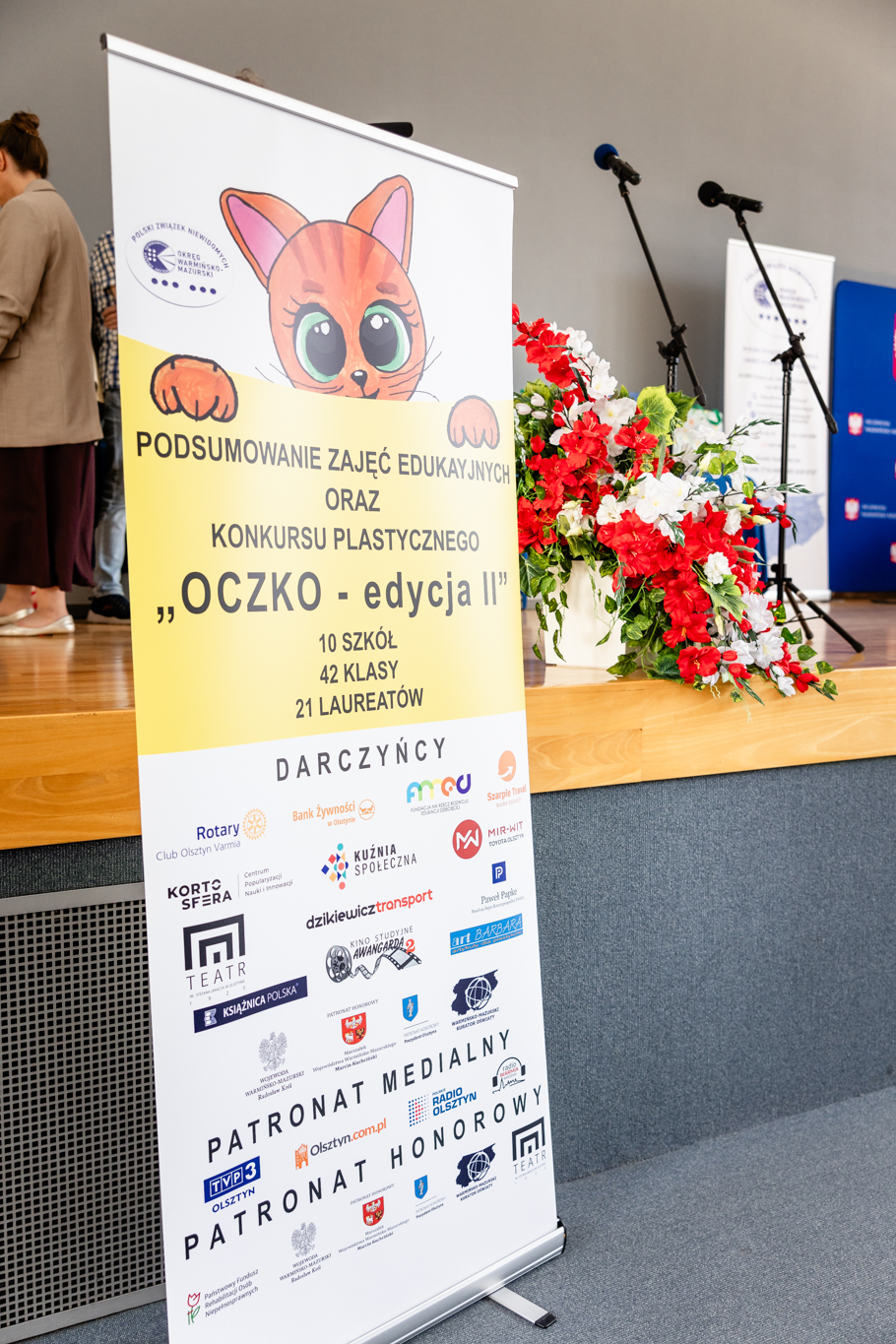 Scena a przed nią rolup z informacjami o konkursie plastycznym "OCZKO - edycja II"