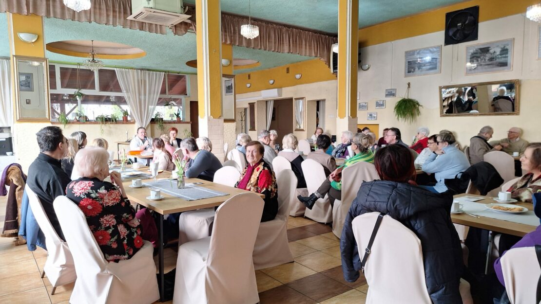 duża sala zapełniobna ludzmi siedzacymi przy stolikach