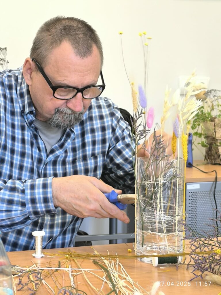 męzczyzna robi swój lampion, podcina cążkami drucik