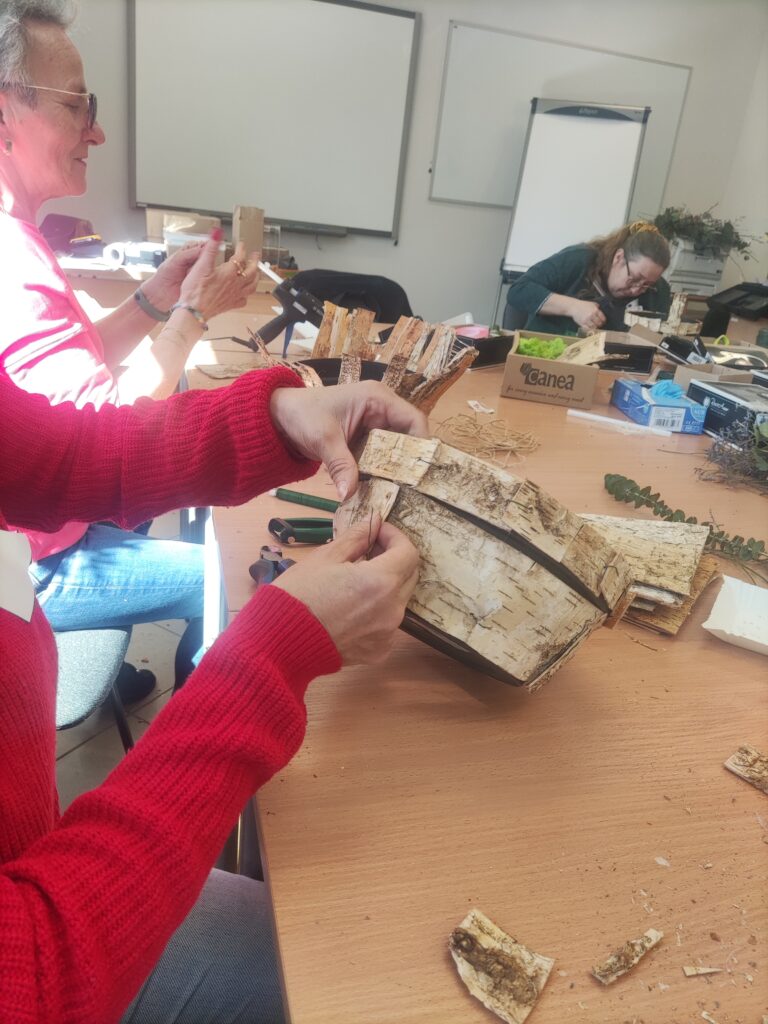 uczestniczka obkleja doniczkę kora