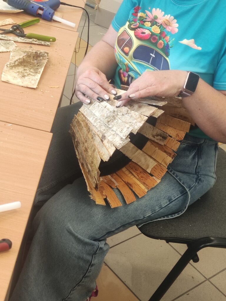 uczestniczka obkleja doniczkę kora